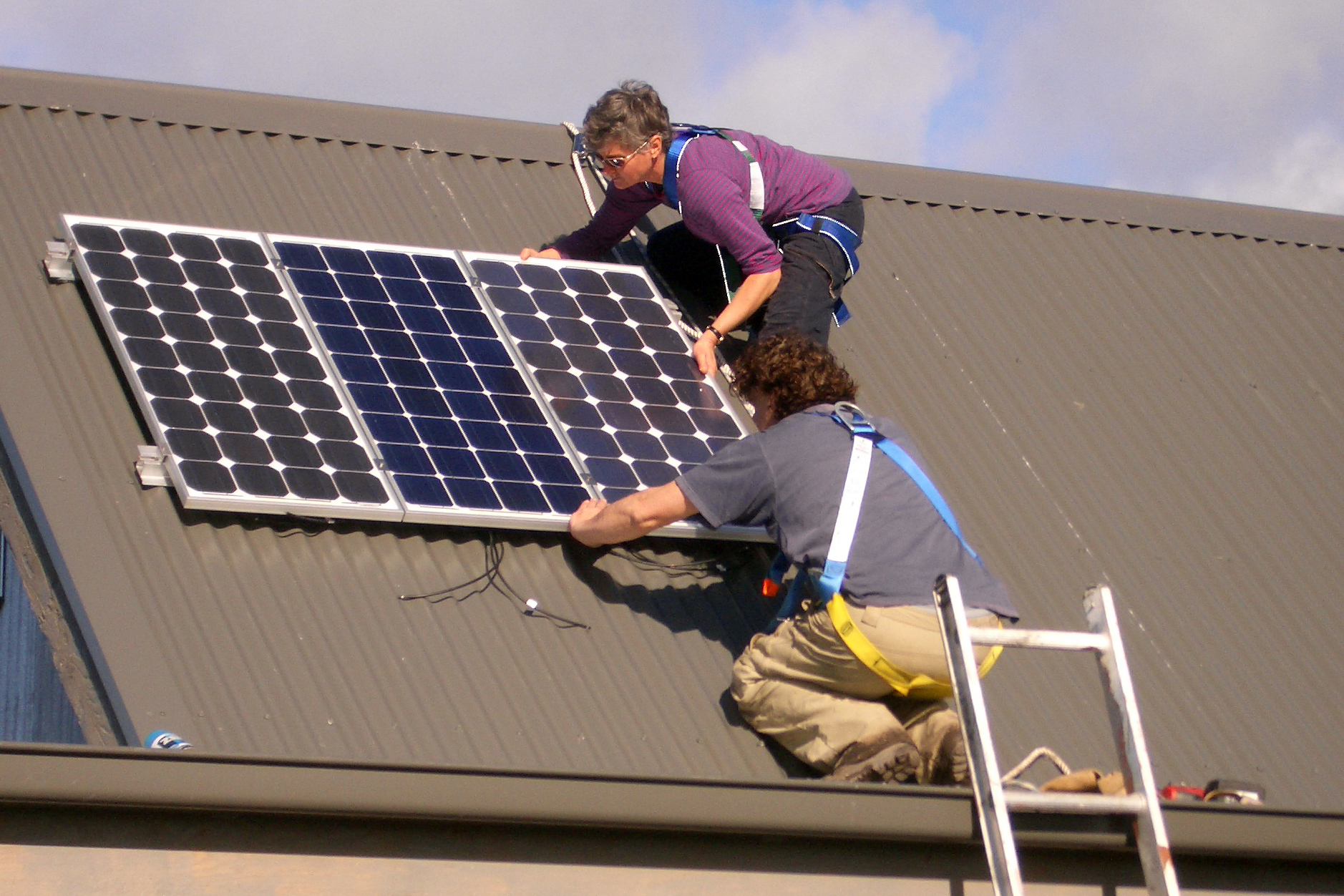 Anneke Deutsch and a colleague install solar panels.